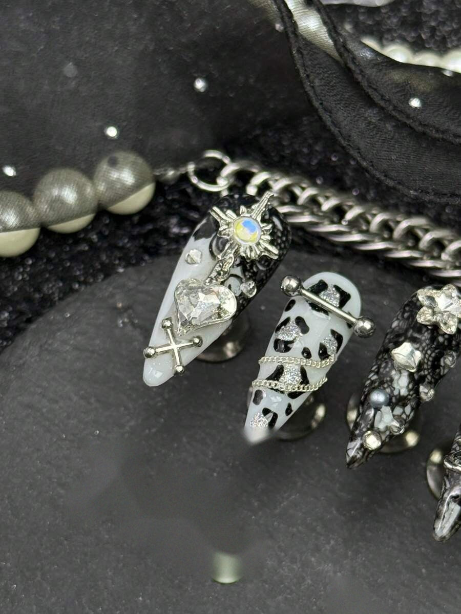 Close detail of the silver star charm and draped chain on the cow print nails