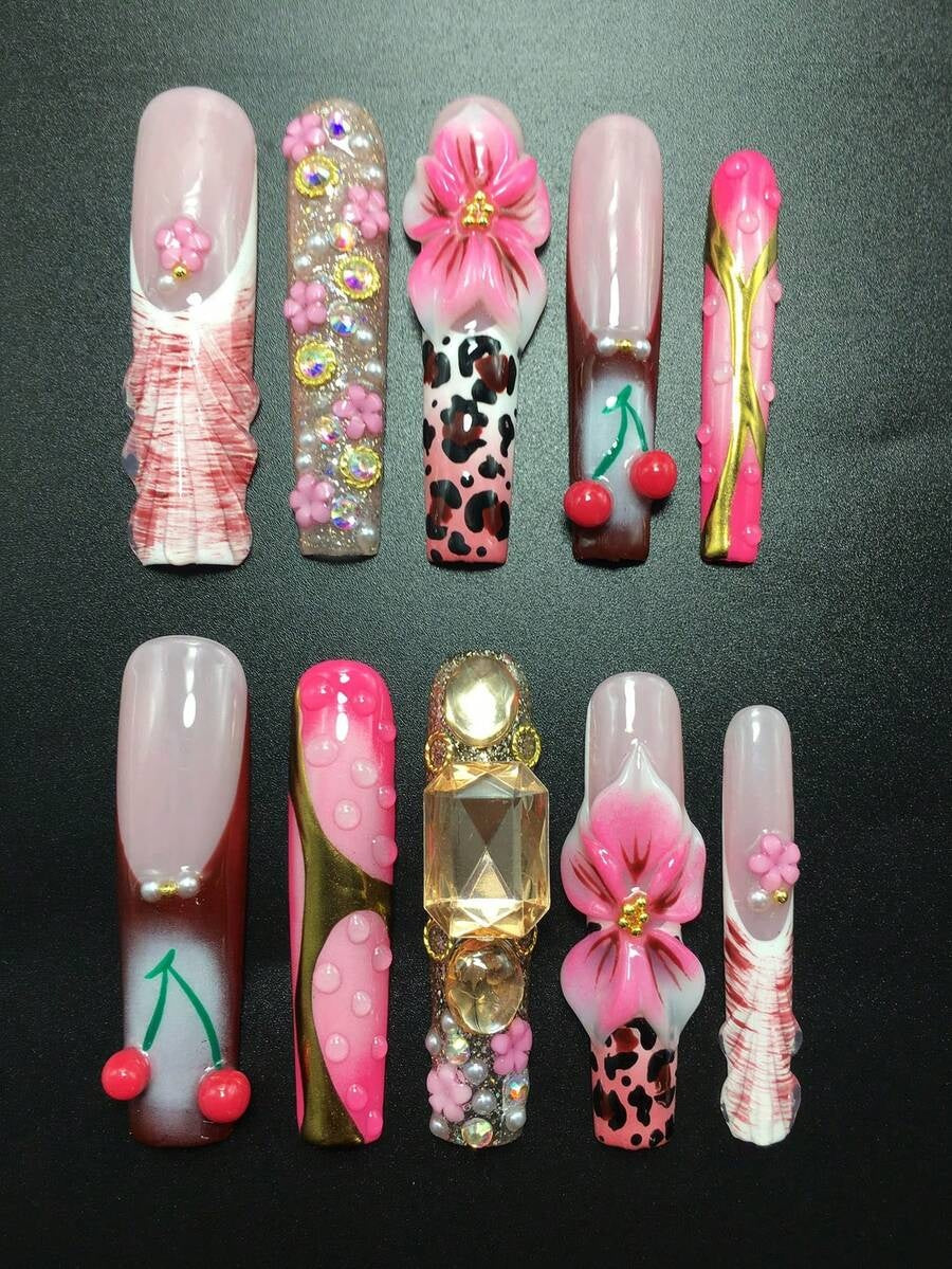 Full set of cherry and leopard press-on nails laid out by finger