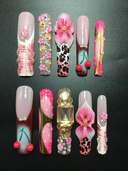 Full set of cherry and leopard press-on nails laid out by finger