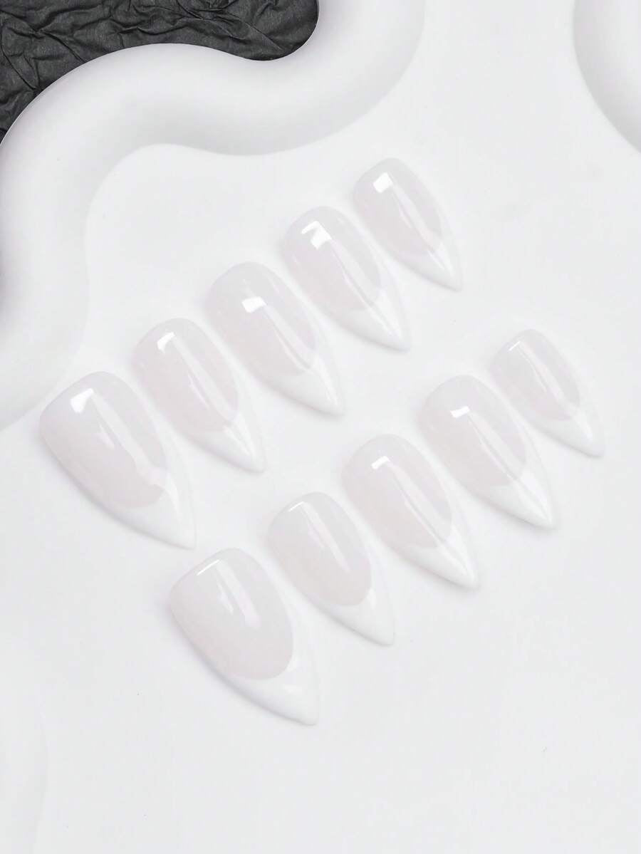 Full set of milky French almond press-on nails laid out by finger