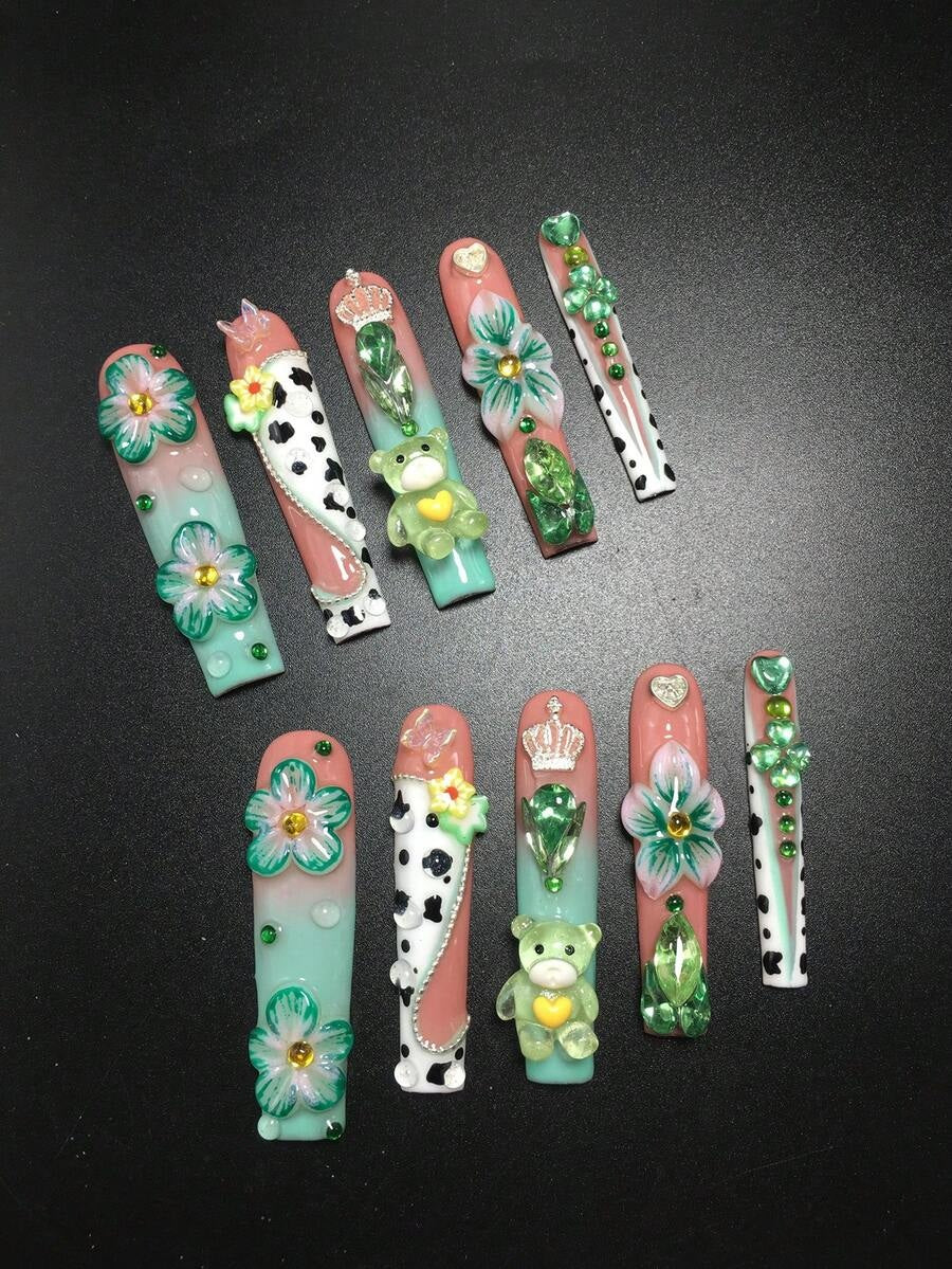 Mint and peach coffin nails laid out showing 3D flowers and green crystals