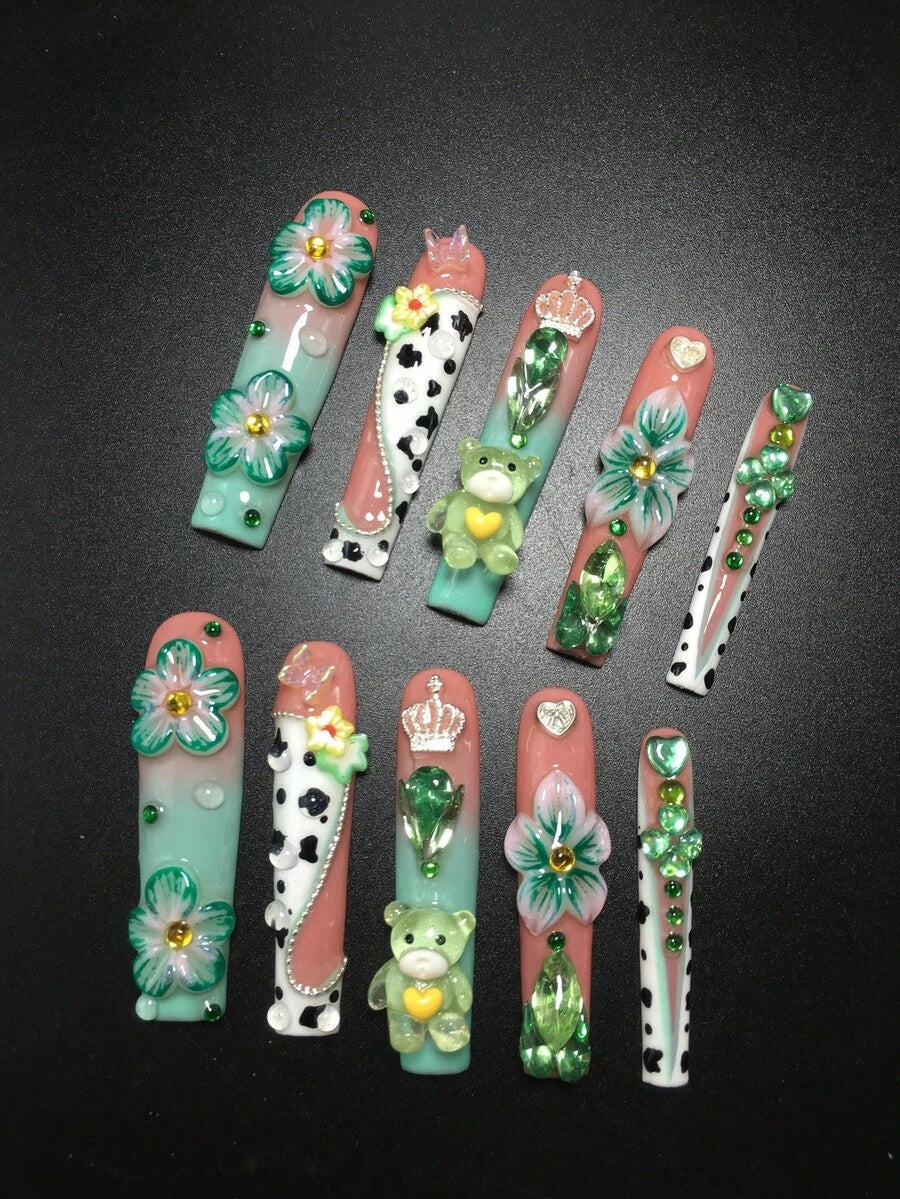 Close view of the cow print, teddy bear and crown details on extra long coffin nails