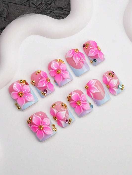 Short square press-on nails with baby blue French tips and 3D pink hibiscus flowers
