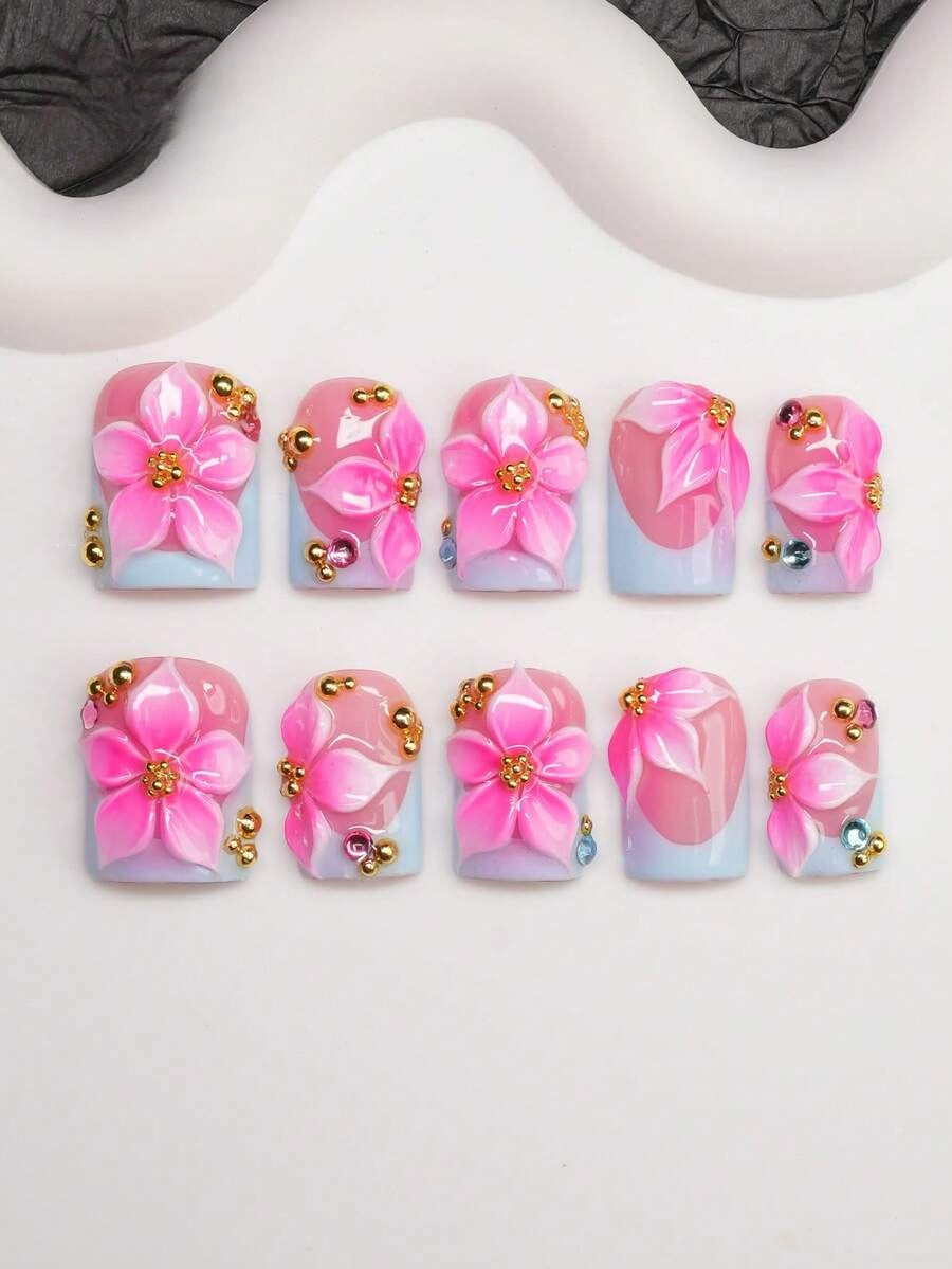 Full set of pink hibiscus press-on nails laid out by finger