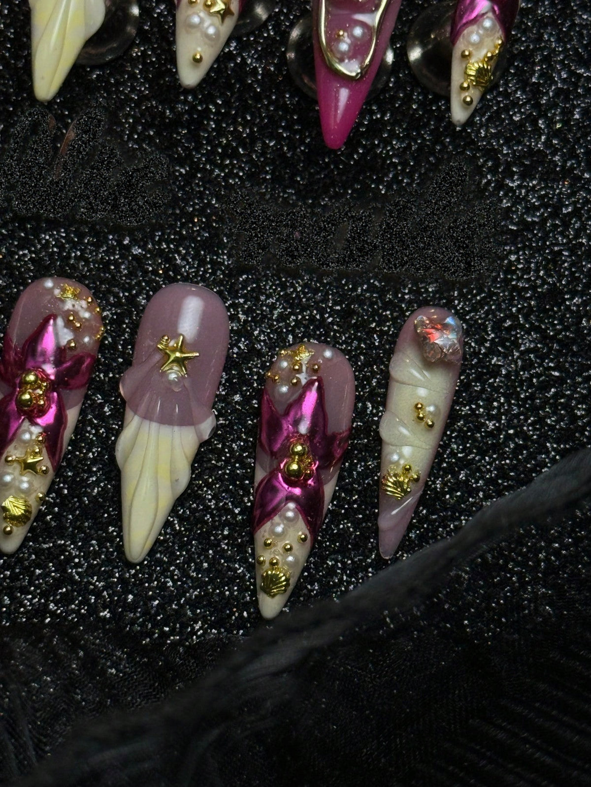 Pink and cream stiletto press-on nails with opal gem and shells, detail view
