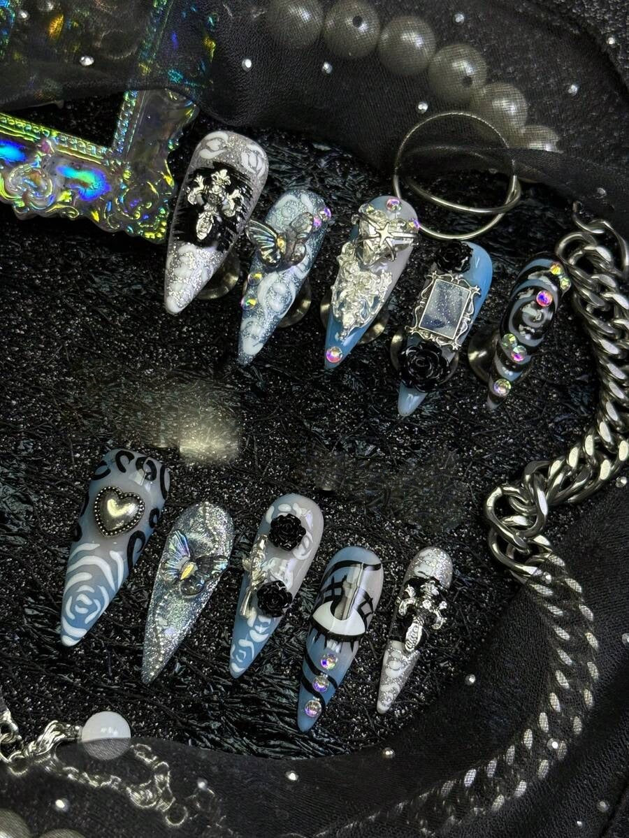 Frostbite Rose stiletto nails shown on a black display