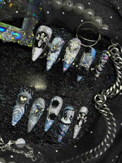 Frostbite Rose stiletto nails shown on a black display