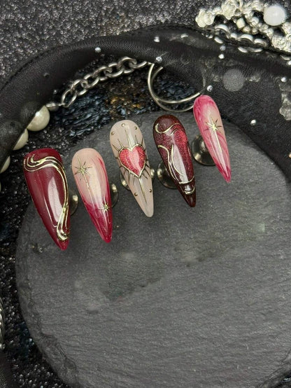 Bleeding Heart stiletto nails with glitter red hearts and gold stars